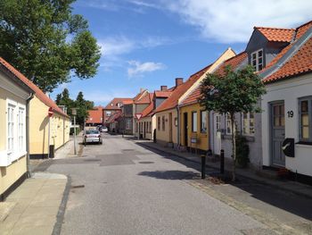 Road amidst buildings in city against sky