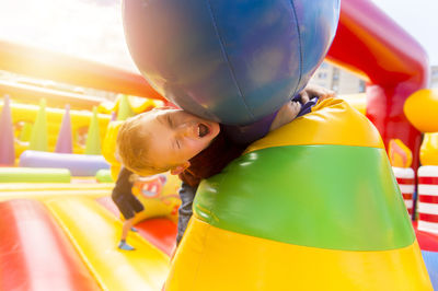 Portrait of boy playing on colorful bouncy castle