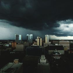 Buildings in city against cloudy sky