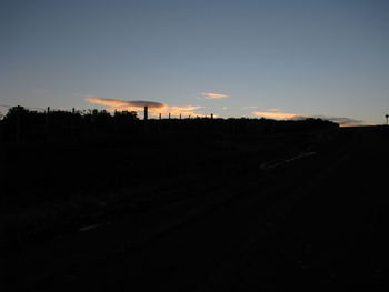 Silhouette road against sky during sunset