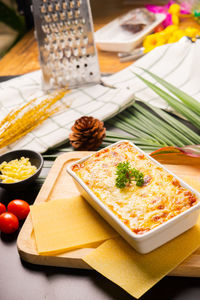 High angle view of lasagne in container on cutting board