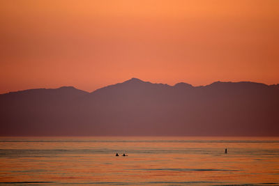 Scenic view of mountains against orange sky