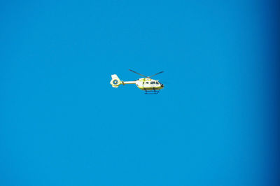 Low angle view of airplane against clear blue sky