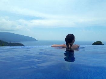 Man in swimming pool in sea against sky