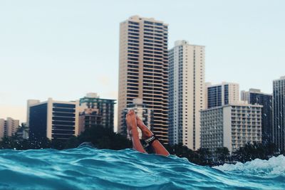 Man in swimming pool against cityscape