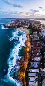 Aerial view of cityscape by sea against sky