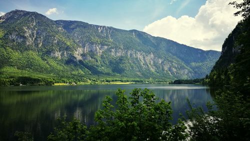 Scenic view of lake by mountains against sky