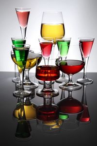 Colorful drinks in glasses against white background