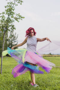 Woman dancing on field against trees