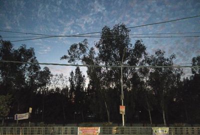 Power lines against cloudy sky