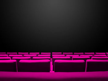 Empty chairs against black background