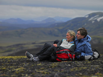 Hiking couple relaxing on mountainside in iceland