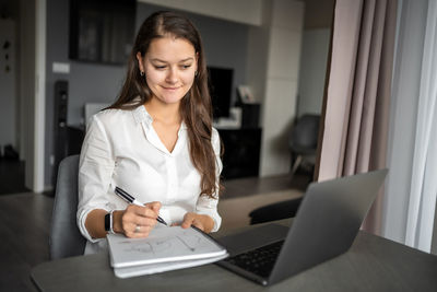 Young woman using laptop at home