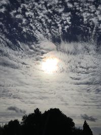 Silhouette of trees against cloudy sky