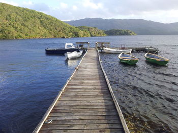 Jetty with moored boats leading to calm sea