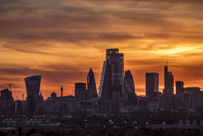 Modern buildings against sky during sunset