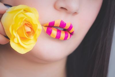 Cropped image of woman with yellow and pink lipstick