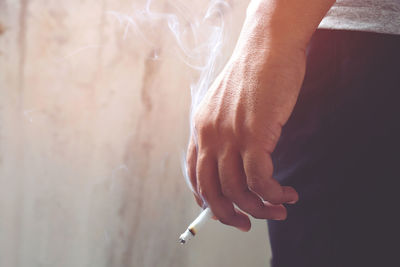 Close-up of hand holding cigarette