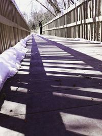 Shadow of man walking on footpath