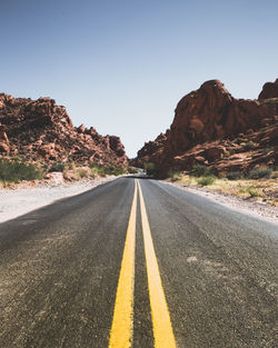 Road amidst mountains against clear sky