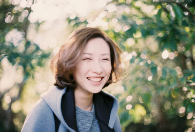 Close-up of young woman smiling at park
