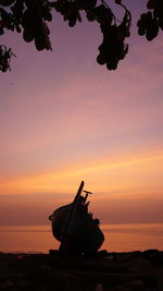 Silhouette boat by sea against sky during sunset