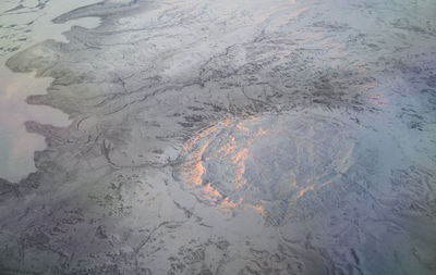 Snowy mountains catching the sunset light from an airplane.