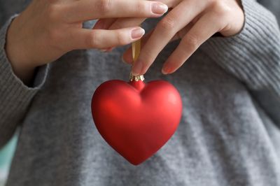 Midsection of woman holding heart shape