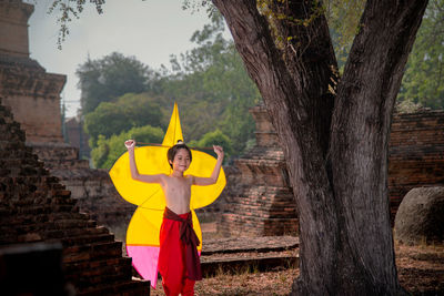 Full length of a woman standing on tree trunk