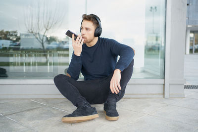 Young man with headphones on city street