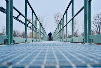 Rear view of man standing on snow covered landscape against sky