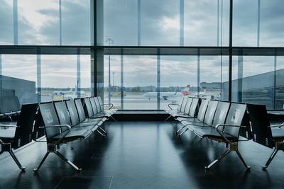 Empty chairs in rows at airport lounge