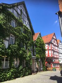 Street amidst buildings against blue sky during sunny day