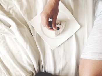 Person holding toothpick and eating cake