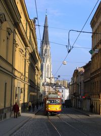 Cars on street amidst buildings in city against sky