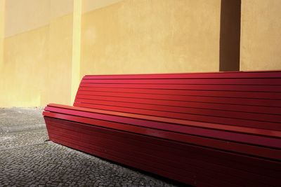 Empty bench against wall in building