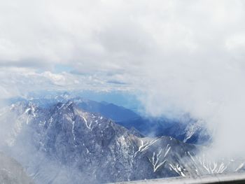 Aerial view of snowcapped mountains against sky