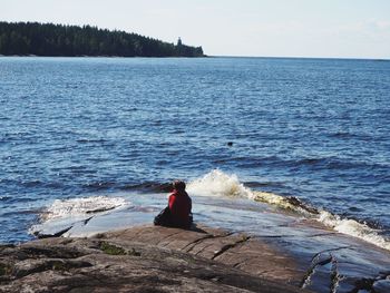 Rear view of woman looking at sea against sky