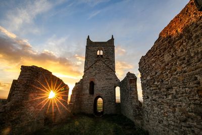 Low angle view of bell tower at sunset