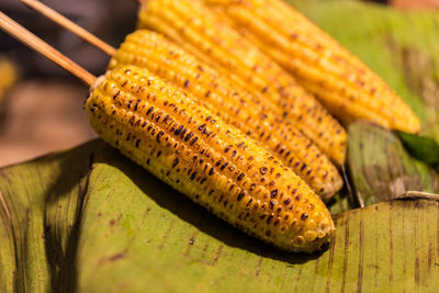 High angle view of roasted sweetcorns on banana leaf