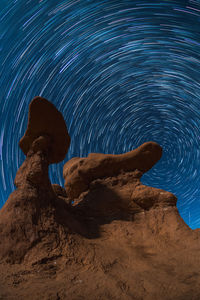 Low angle view of rock formation against sky at night
