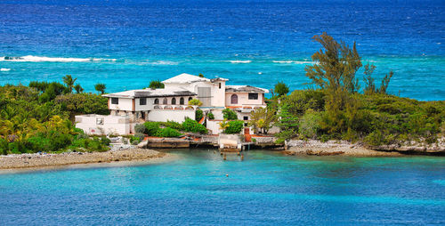 Buildings by sea against sky