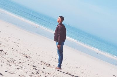 Full length of young man standing on beach