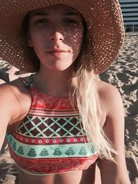 Portrait of young woman wearing hat at beach