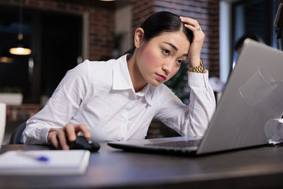 Young businesswoman using laptop at office