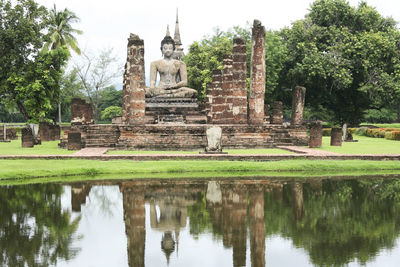 Reflection of temple on building in lake