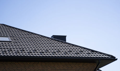 Low angle view of building roof against clear sky