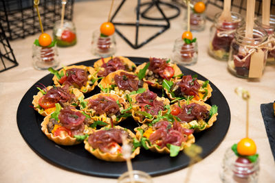 Thin pastry tartlets with caramelized onions, roasted mushrooms, cherry tomatoes