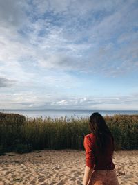 Rear view of woman standing on beach