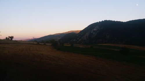 Scenic view of field against clear sky during sunset